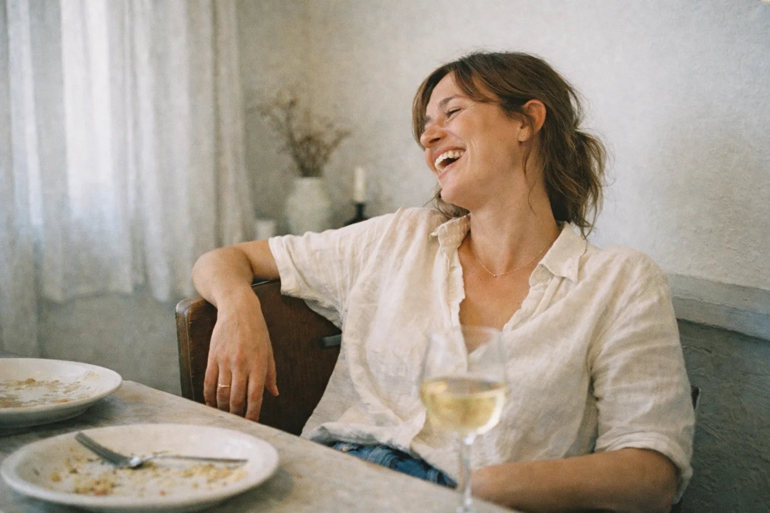 Woman laughing at dinner table